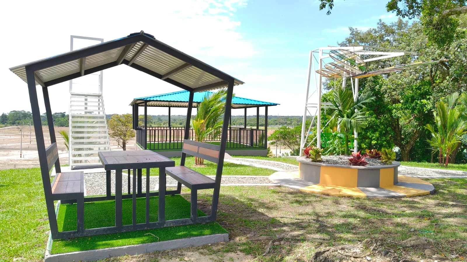 Mesa techada con vista a kiosco y jardinera