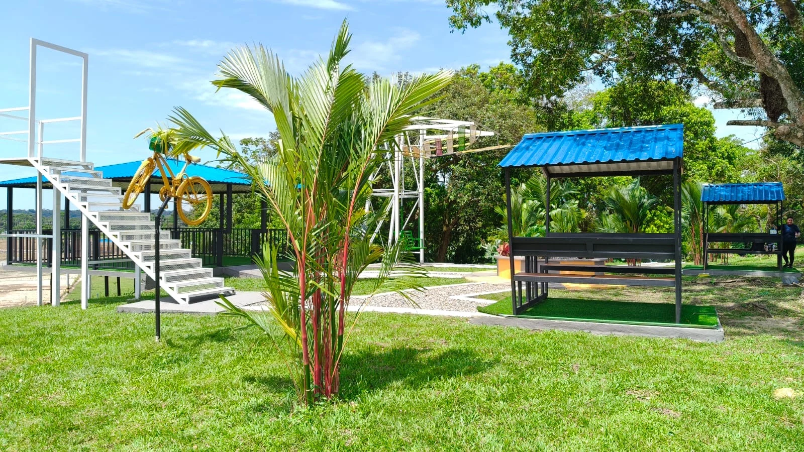 Jardín con palmas, escalera mirador y kioscos con mesas
