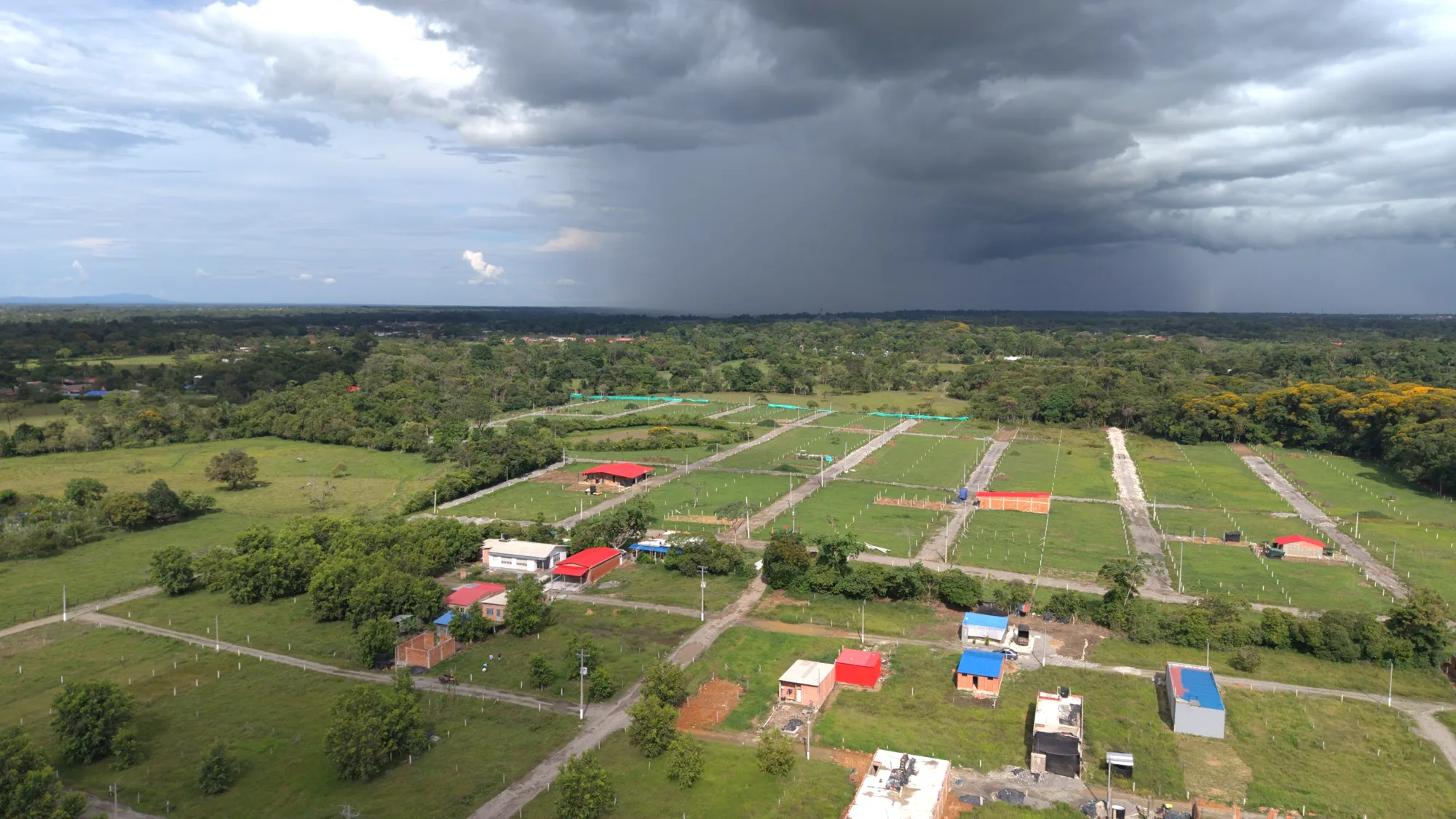 Vista aérea de Senderos del Bosque con lotes demarcados, vías abiertas, viviendas y bosque alrededor